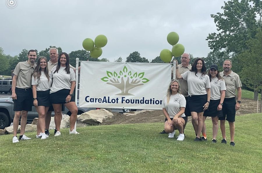 Michael Hovis with the CareALot Foundation team behind their banner