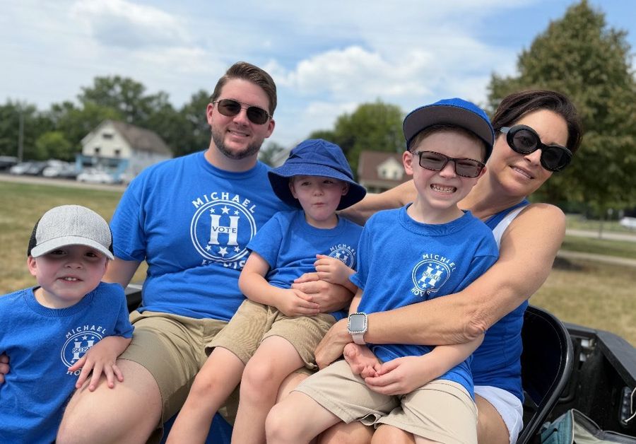 Hovis family members in blue Michael Hovis shirts at a parade